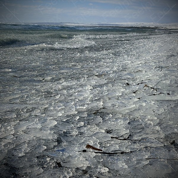 Schritte auf Eissplittern am Black Sand Beach