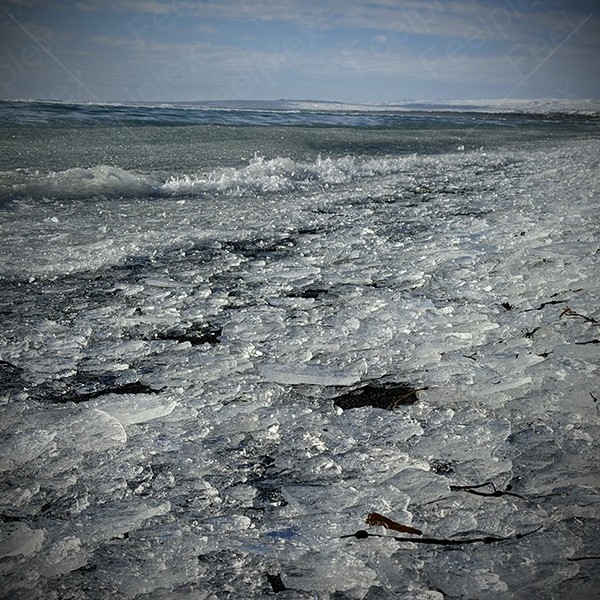 Schritte auf Eissplittern am Black Sand Beach