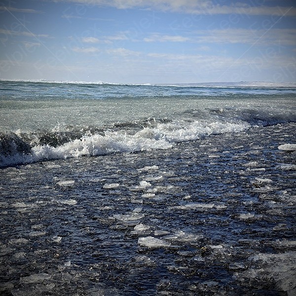 Schritte auf Eissplittern am Black Sand Beach