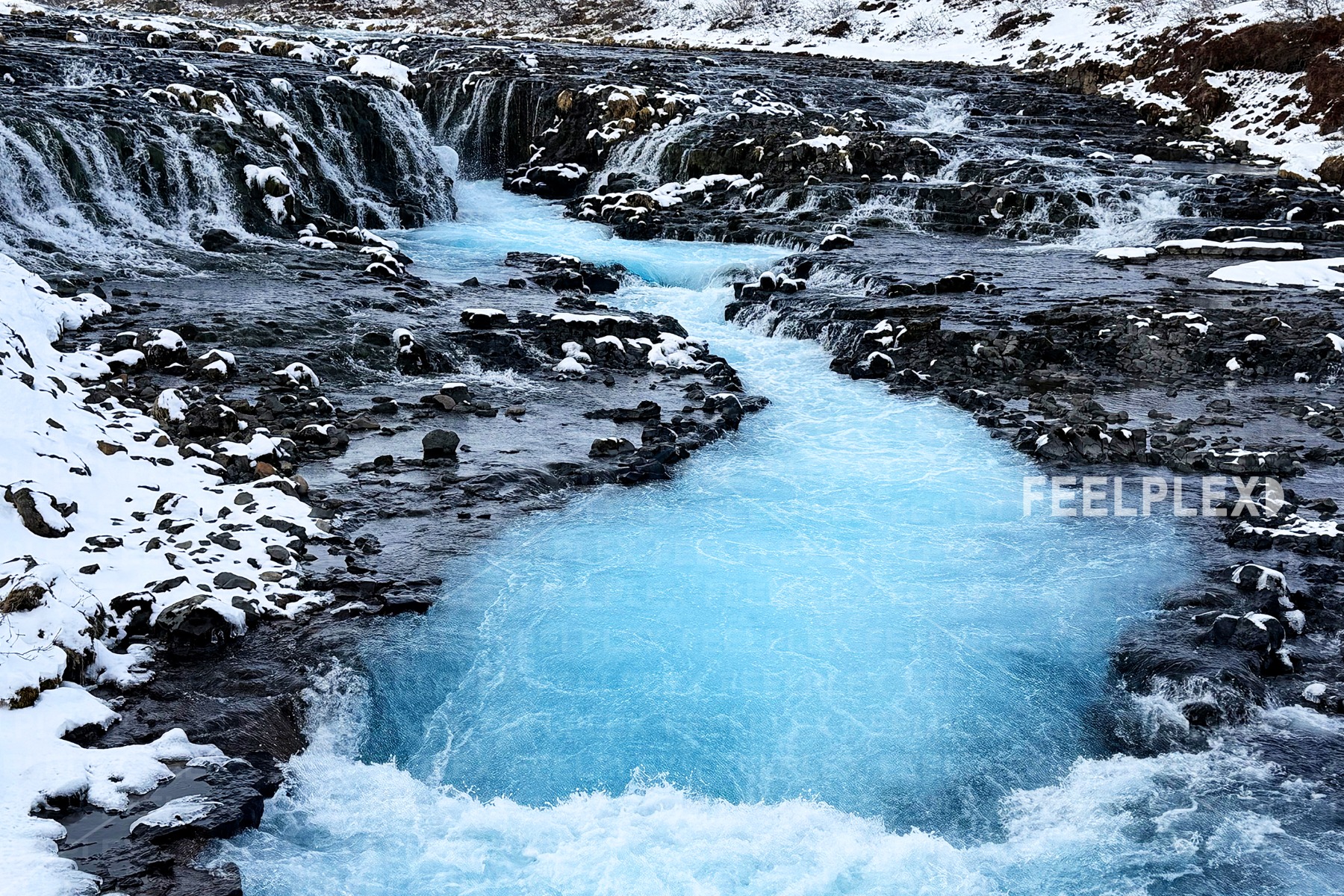 Smaragdblaue Strömung zwischen dunklen Felsen
